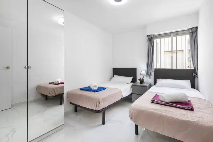 Twin bedroom with two single beds and mirrored wardrobe